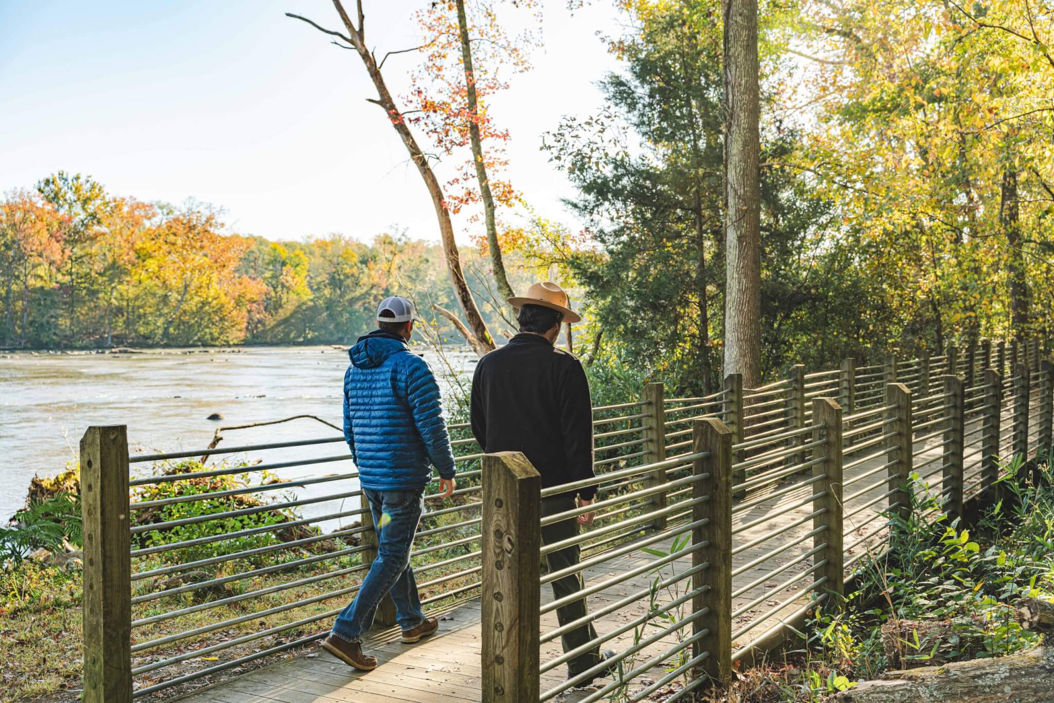 two adults walking on a bridge along the Carolina Thread Trail